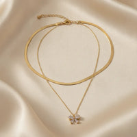 Gold-toned double snake chain choker necklace with double snake layers and a sparkling bow pendant charm