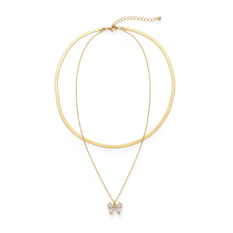 Gold-toned double snake chain necklace with double-layer sleek band and delicate chain featuring a sparkling bow charm