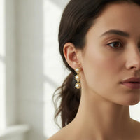 Gold-toned triple pearl dangle earrings with three cascading pearl beads in a delicate floral metal setting