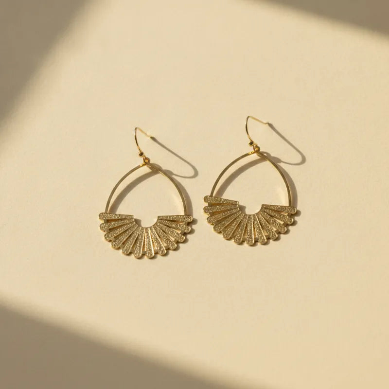 Elegant gold fan teardrop statement earrings with a textured glittery finish in a gold-toned metal design