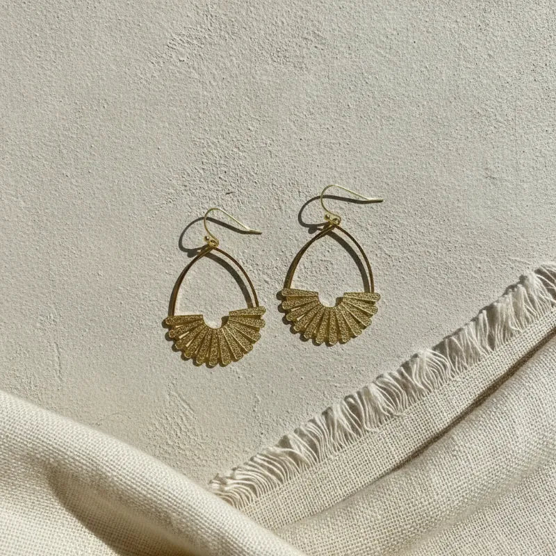 Elegant gold fan teardrop statement earrings featuring gold-toned fan-shaped hoops with a textured glittery finish