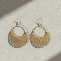 Gold-toned filigree metal drop earrings with intricate boho mandala-style cutout patterns for elegant wear