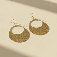 Gold-toned boho filigree metal drop earrings with intricate leaf-patterned detailing in a hoop design
