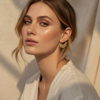 Gold-toned semi-circular cutout hoop earrings with intricate botanical cutout design for chic statement jewelry