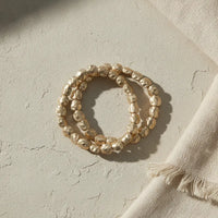 Gold-toned hammered gold stretch bracelet featuring irregular textured beads in a stylish bracelet stack design