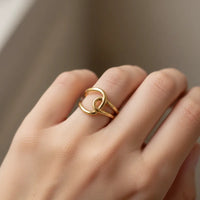 Gold-toned interlocked water resistant ring with a sleek minimalist knot design ideal for everyday wear