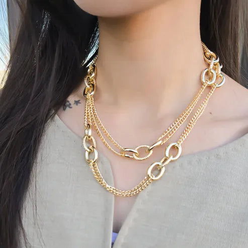 Gold-toned mixed link chain necklace featuring layered interlocking oval and curb links for stylish wear