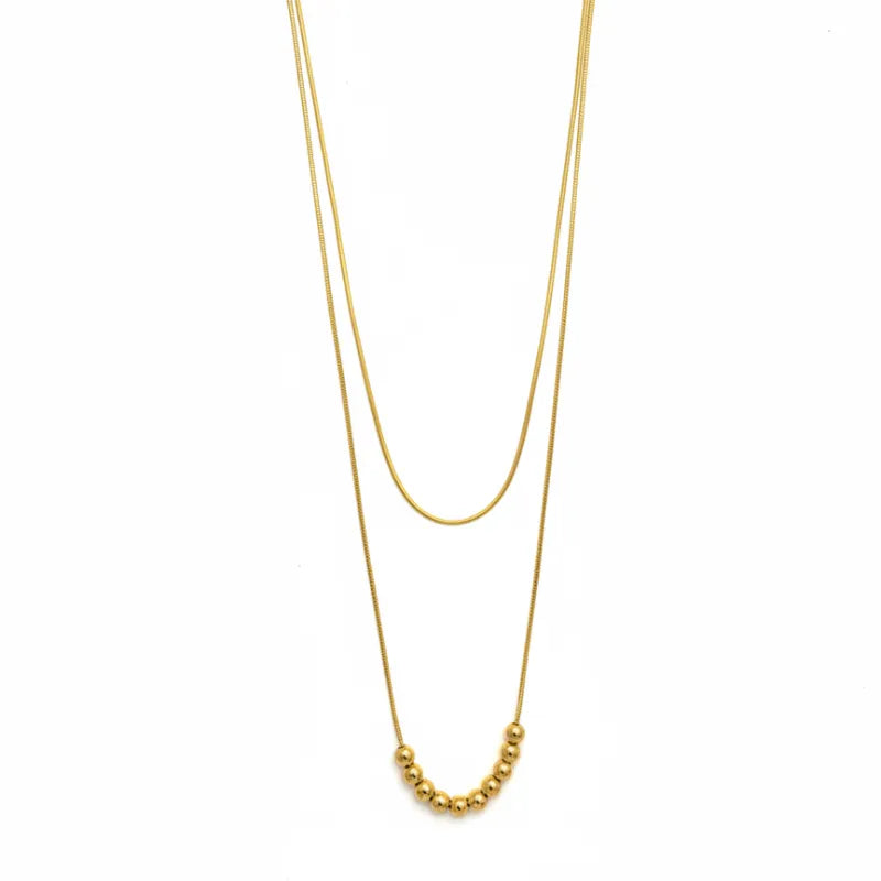 Gold beaded layered necklace featuring a gold-toned snake chain and curved row of polished spherical beads