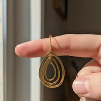 Gold-toned multi oval shape teardrop earrings with layered design and wire hook