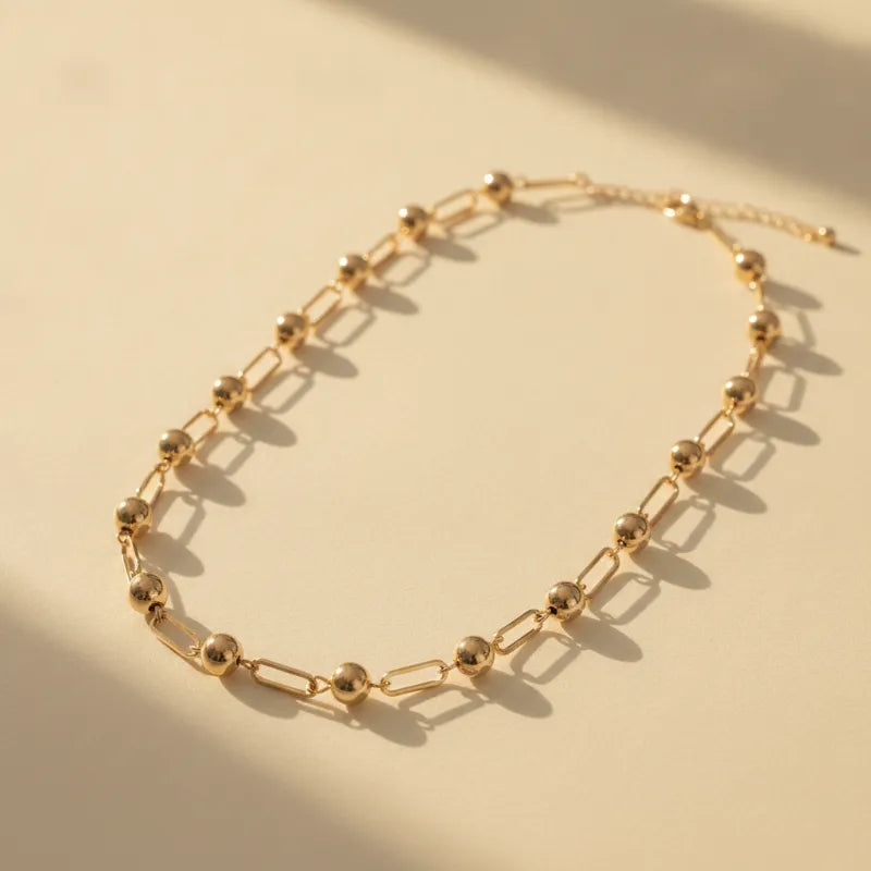 Chic minimalist gold ball and bar link chain necklace featuring gold-toned spherical beads and rectangular links