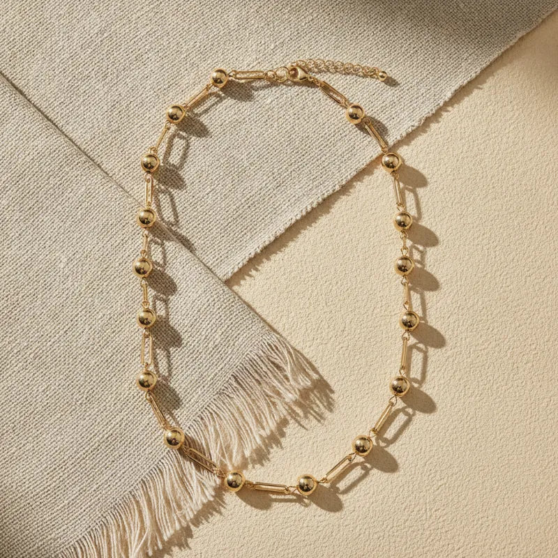 Chic minimalist gold ball and bar link chain necklace featuring gold-toned spherical beads and rectangular links