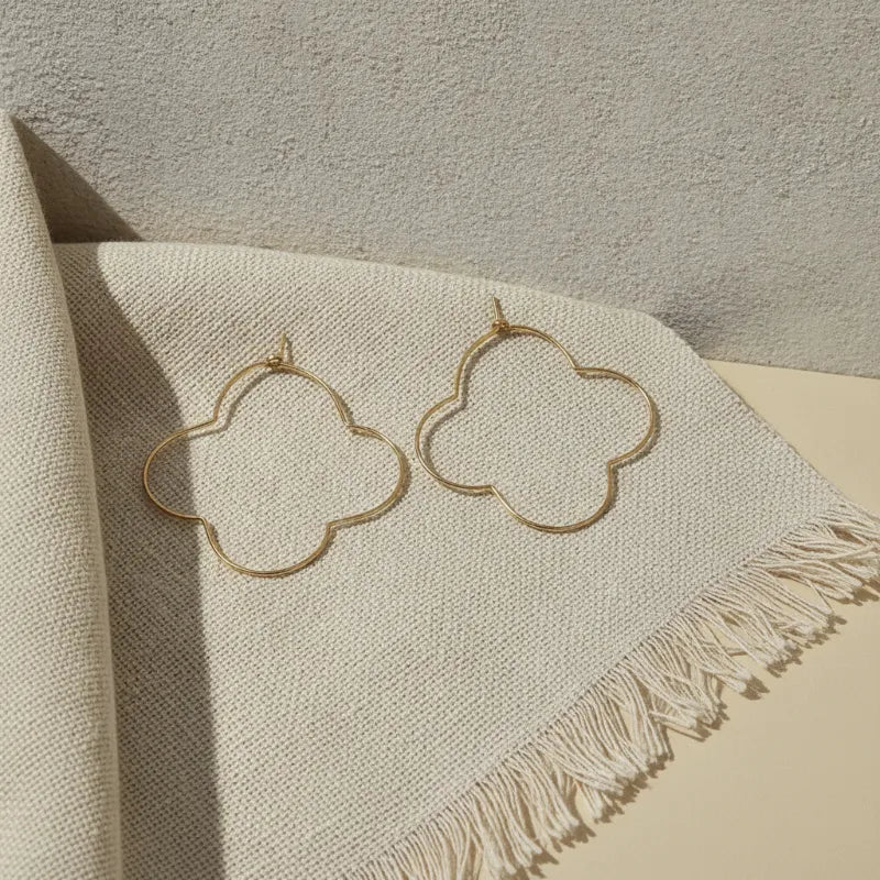 Gold clover hoop earrings featuring a gold-toned minimalist open-frame quatrefoil design for elegant wear