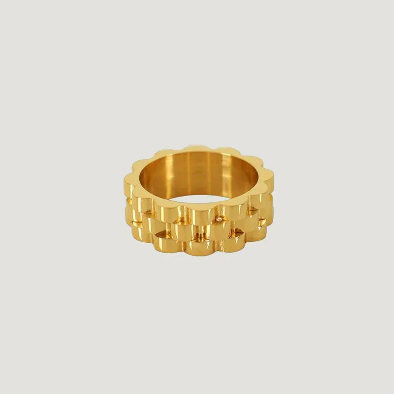 Gold curve ring in gold tone featuring a textured gear-like design with interlocking rectangular segments