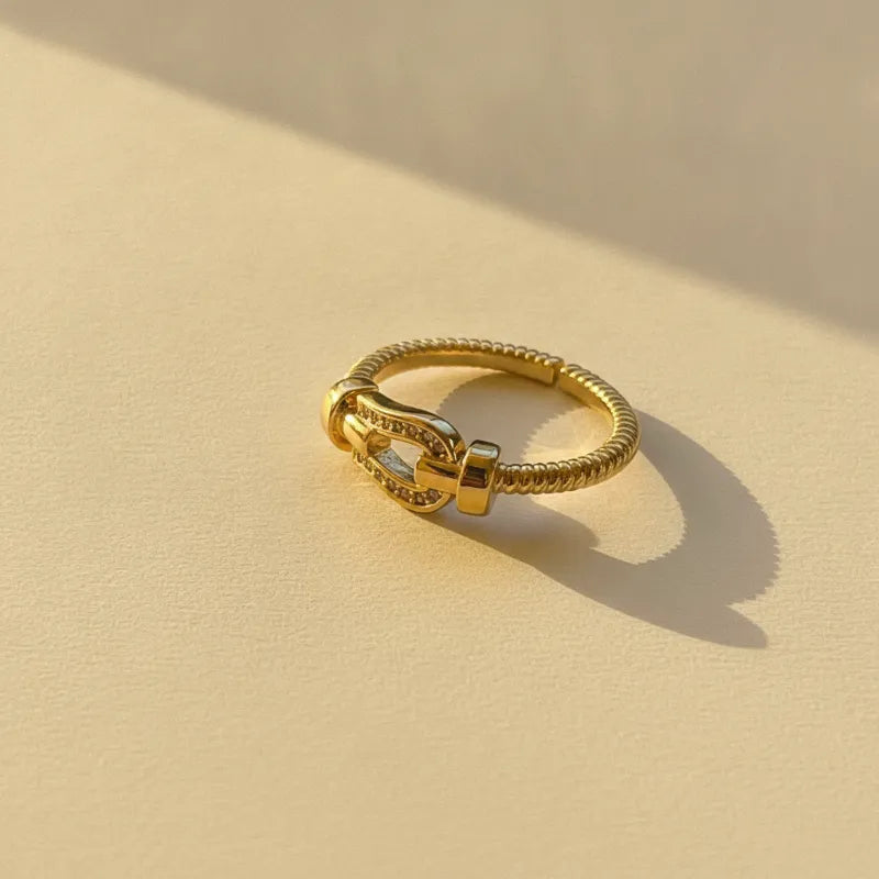 Gold plated cable band statement ring with twisted design and buckle centerpiece adorned with sparkling stones