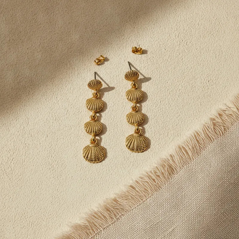 Elegant three-tier gold seashell drop statement earrings featuring a textured scalloped stacked design