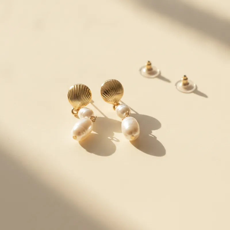 Gold seashell pearl drop earrings featuring a double pearl drop design in gold-toned metal for elegant wear