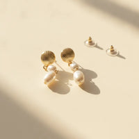 Gold seashell pearl drop earrings featuring a double pearl drop design in gold-toned metal for elegant wear
