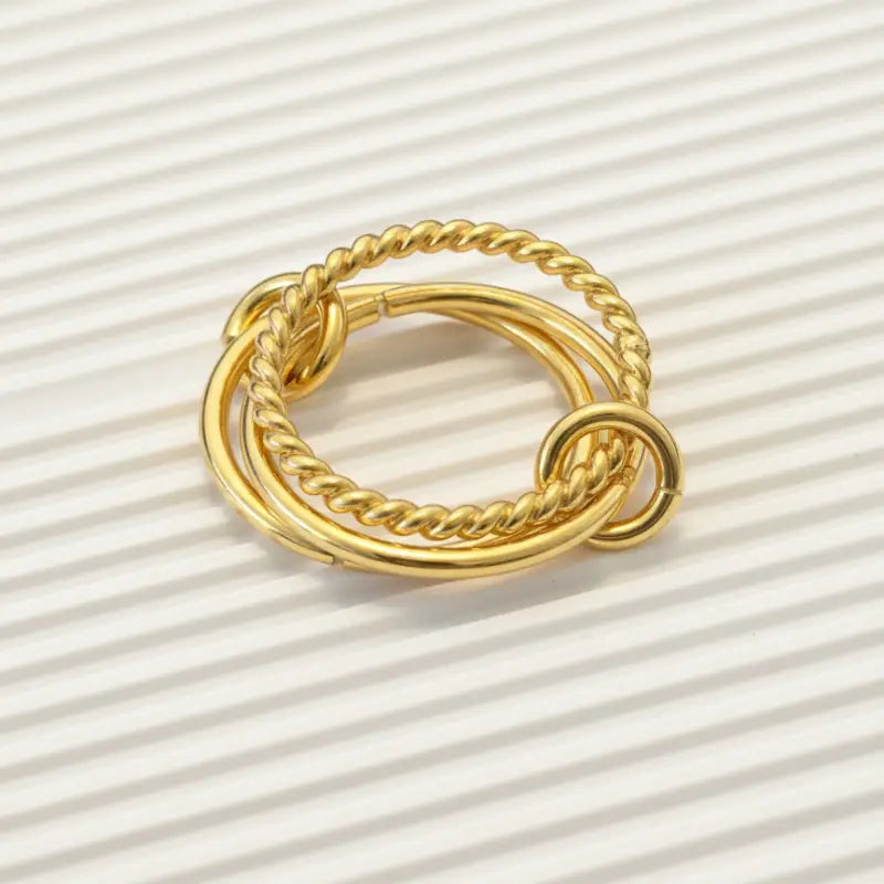 Twisted gold dip ring featuring gold-toned twisted rope design with interlocking circular bands