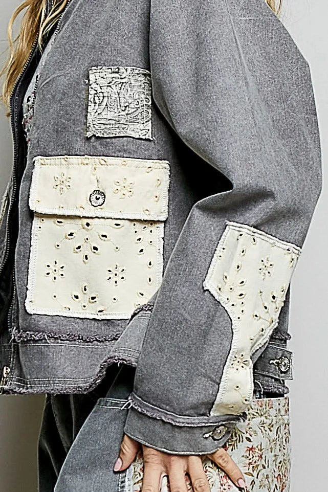 A gray denim jacket with cream embroidered patchwork details featuring bohemian vintage wash design
