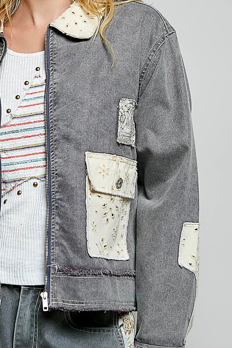 Gray denim jacket with distressed patches and embroidered details featuring a bohemian vintage wash denim design