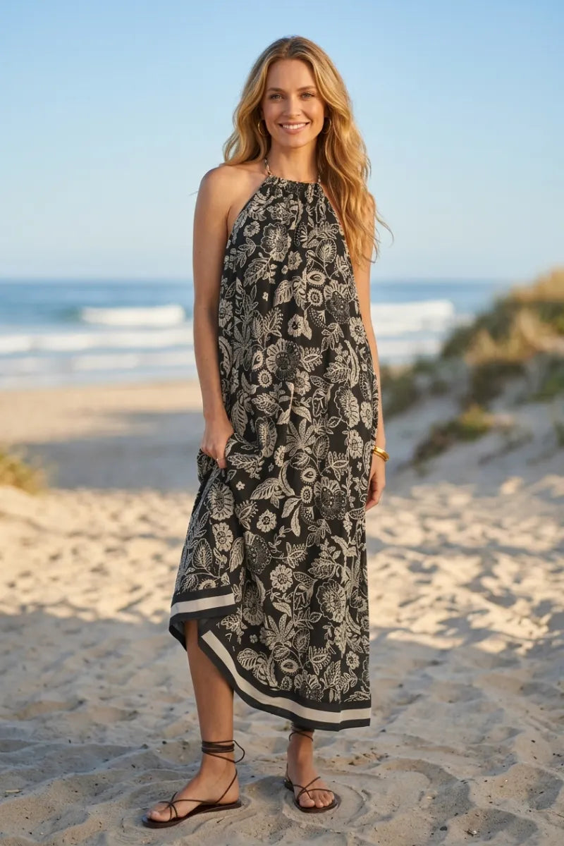 Black and white viento luz floral midi dress featuring a halter neckline and high-low hemline in lightweight fabric