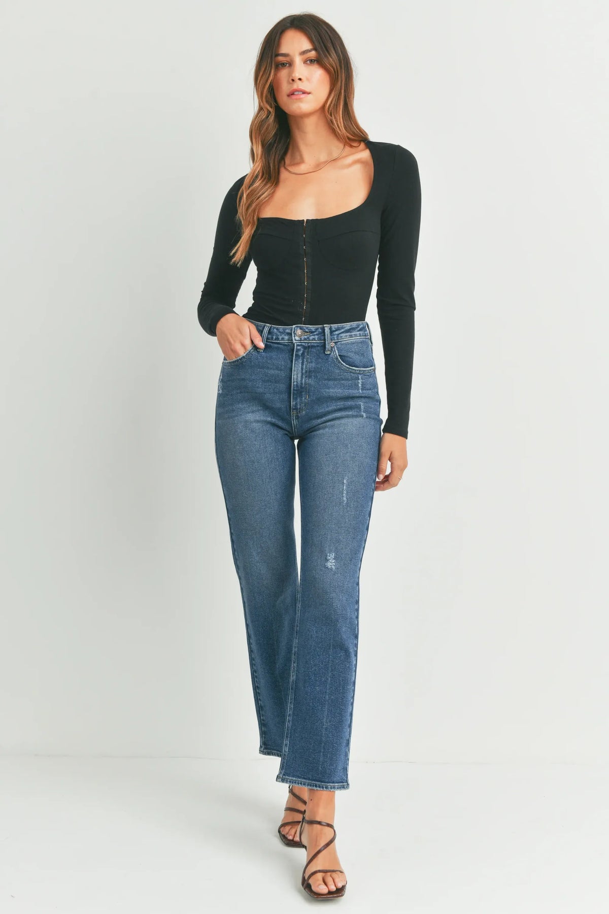 High-waisted blue denim jeans with a length straight cut and subtle distressing in a full length straight denim jean design