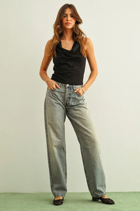High-waisted light wash denim jeans with cowl neck sleeveless top