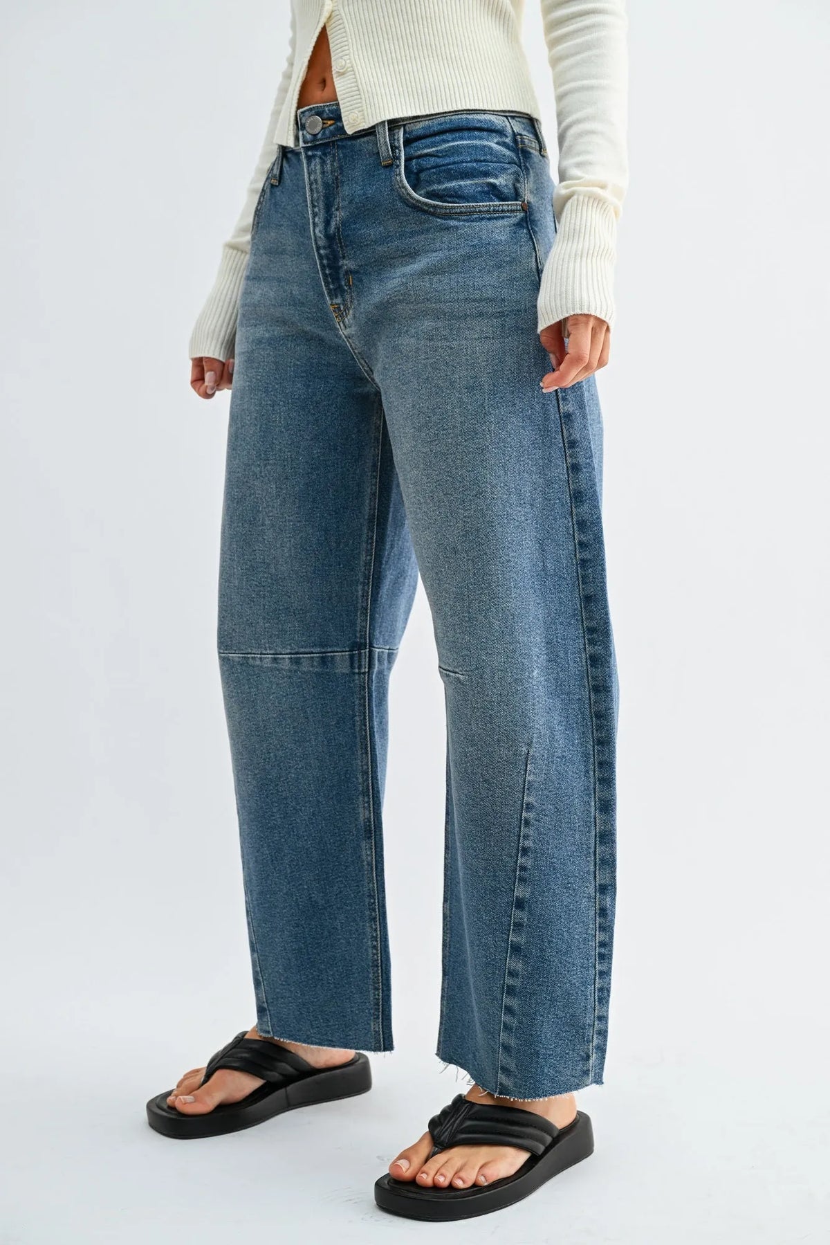 The seamed barrel wide leg denim jeans feature high-waisted medium blue wash jeans with visible stitching and frayed hems