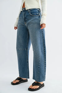 The seamed barrel wide leg denim jeans feature high-waisted medium blue wash jeans with visible stitching and frayed hems