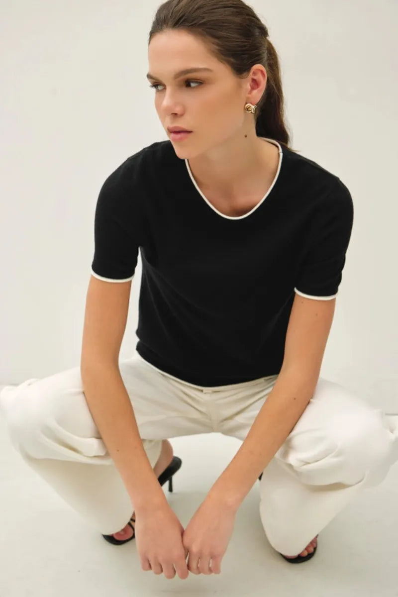 Black layered look essential short sleeve sweater top with white trim on neckline and sleeve cuffs