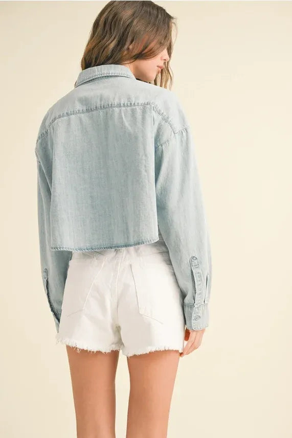 Light blue short body denim shirt with classic collar and buttoned cuffs in a cropped body denim shirt style
