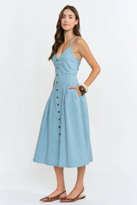 A light blue midi denim dress with v-neckline, button-front detailing, and thin spaghetti straps