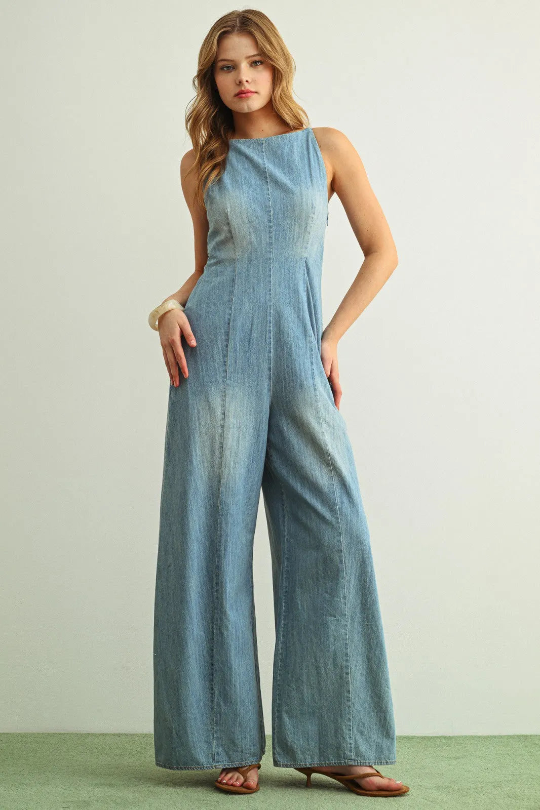 Light blue sleeveless spaghetti strap chambray jumpsuit with high neckline and wide-leg design