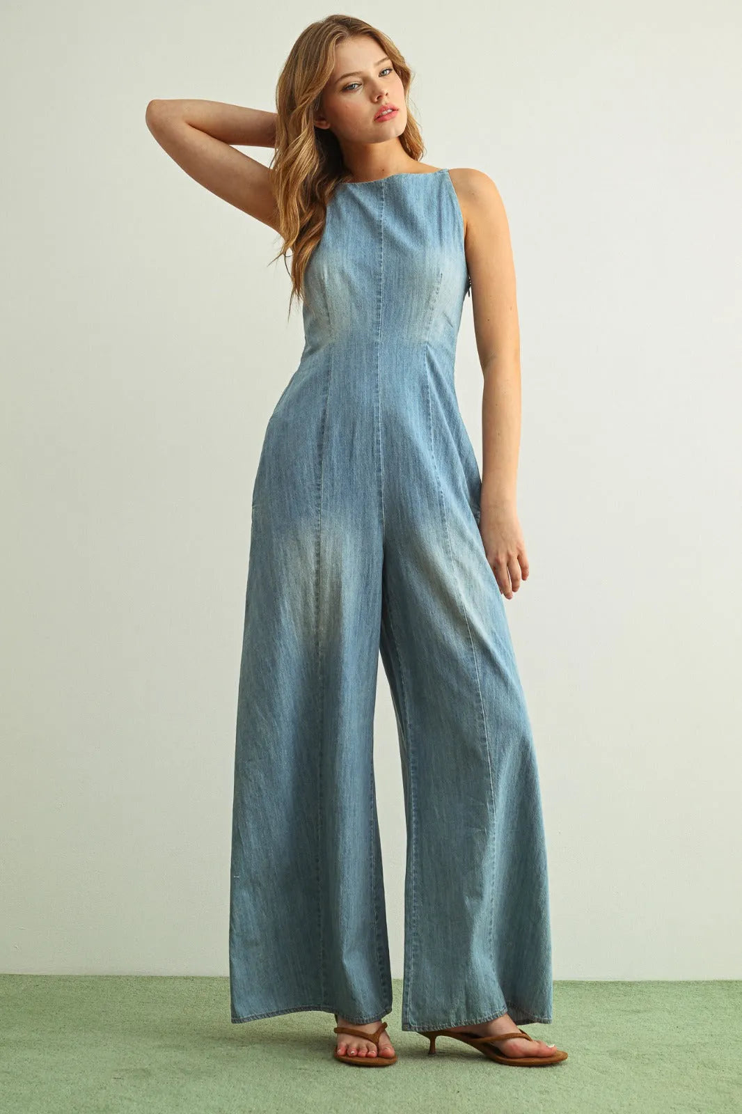 Light blue spaghetti strap chambray jumpsuit with wide-leg design and subtle faded effect