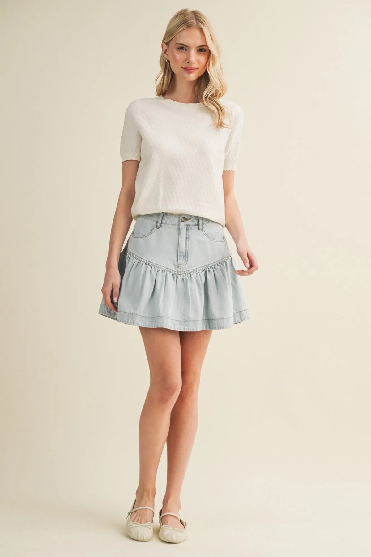 Light blue denim skirt with ruffled hem and classic five-pocket design paired with starburst pointelle puff top