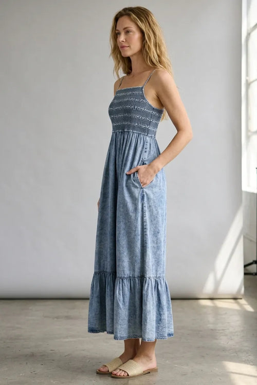 A flowing light blue tencel smocked tiered midi dress with a smocked bodice and tiered skirt