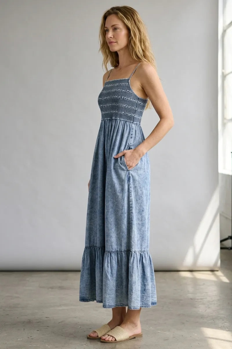 A flowing light blue tencel smocked tiered midi dress with a smocked bodice and tiered skirt