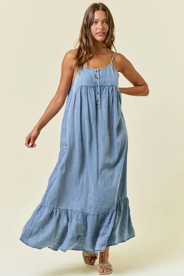 A flowing light blue tencel tiered ruffled midi dress with thin spaghetti straps and a tiered ruffle hem