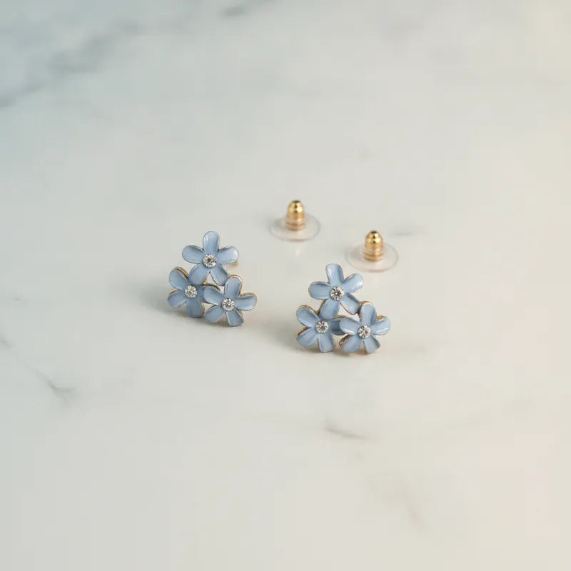 Dainty blue floral enamel stud earrings with clear crystal centers and gold-tone posts for elegant wear