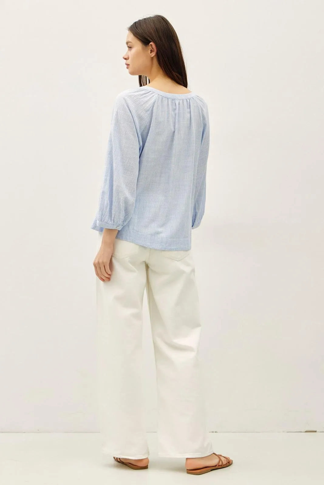 Light blue long-sleeved round neck blouse with buff sleeve button and gathered neckline for elegant wear