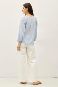 Light blue long-sleeved round neck blouse with buff sleeve button and gathered neckline for elegant wear