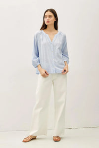 Light blue long-sleeved round neck blouse with gathered neckline and buff sleeve button detail