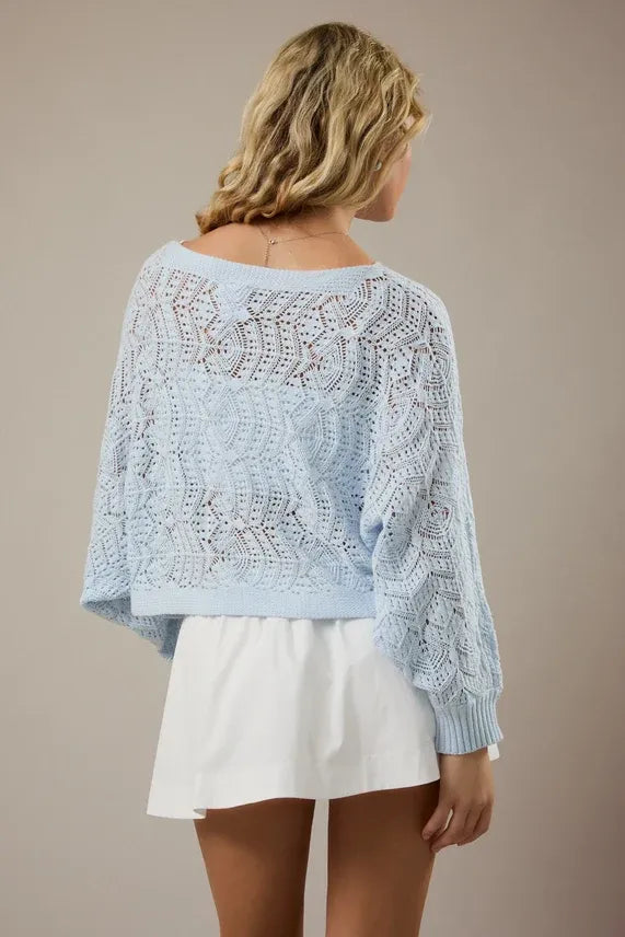 Light blue long sleeve crochet cardigan with intricate lace patterns and ribbed cuffs in open-knit design