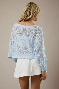 Light blue long sleeve crochet cardigan with intricate lace patterns and ribbed cuffs in open-knit design