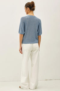 Light blue lightweight ribbed knit raglan short sleeve top shown from the back with textured geometric pattern