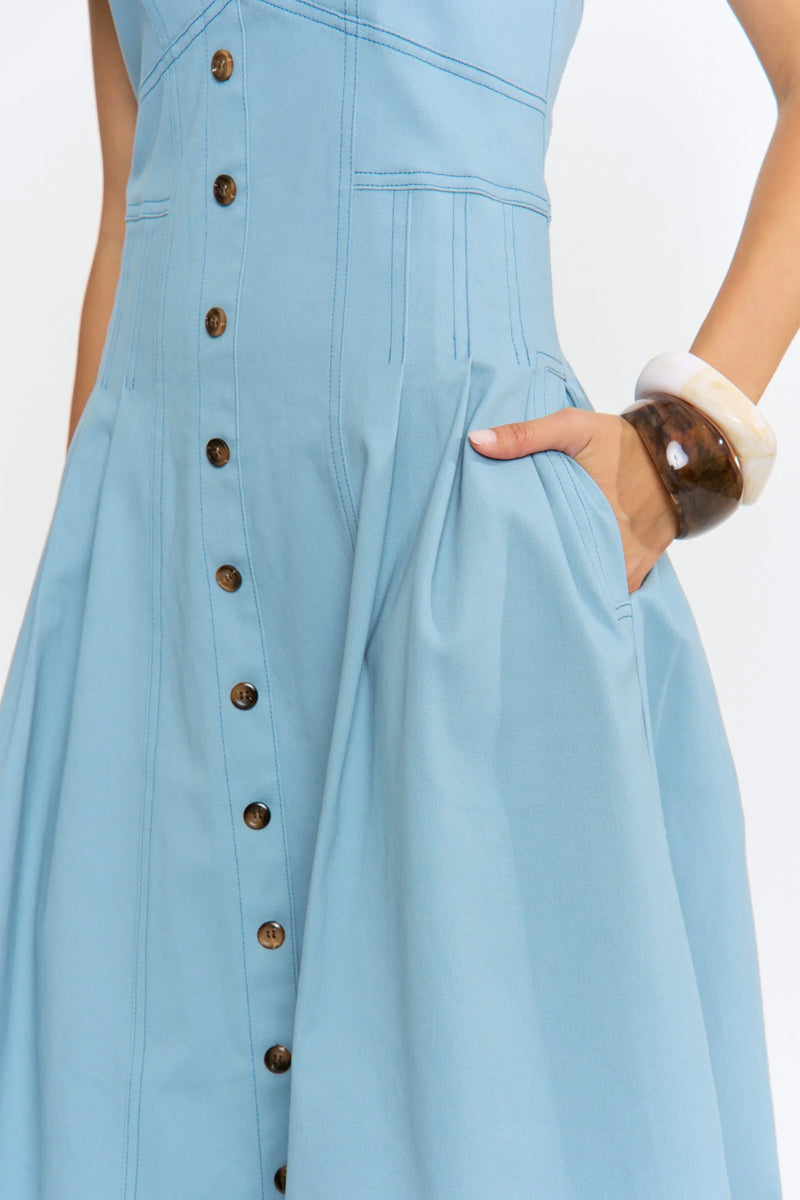A light blue midi denim dress with sleeveless design, button-front detail, and pleated accents