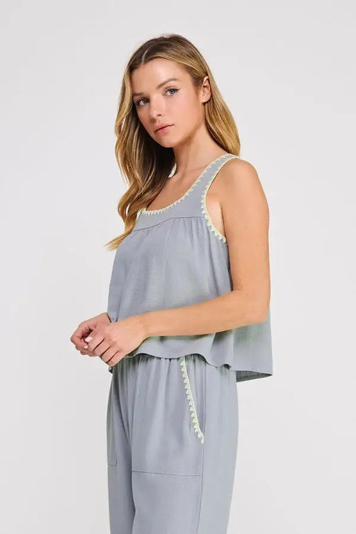 Light blue embroidered linen sleeveless top with delicate cream-colored trim along neckline and side seam