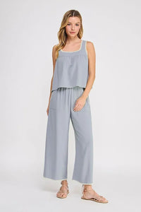 Light blue embroidered linen sleeveless top with delicate white lace trim along neckline and hem