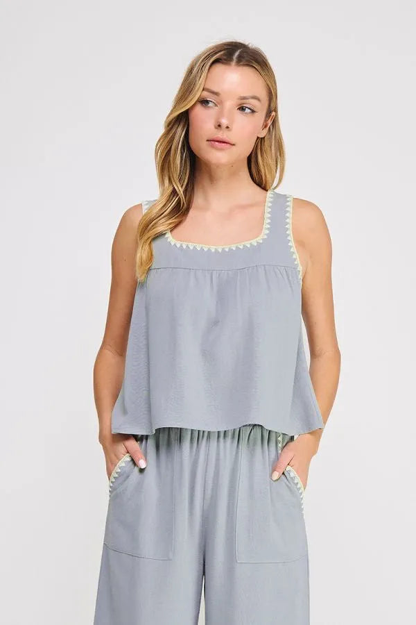Light blue embroidered linen sleeveless top with square neckline and white lace trim along edges