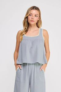 Light blue embroidered linen sleeveless top with square neckline and white lace trim along edges